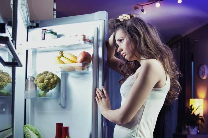 dekle pri hladilniku, medtem ko sledi svoji najljubši dieti